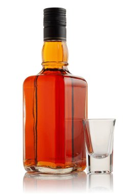 Beyaz arka planda bir şişe alkol ve bir bardak..