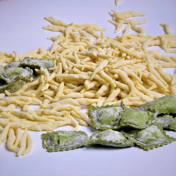 Fresh homemade pasta Italian trophy and agniolotti on a light background, italian traditional food
