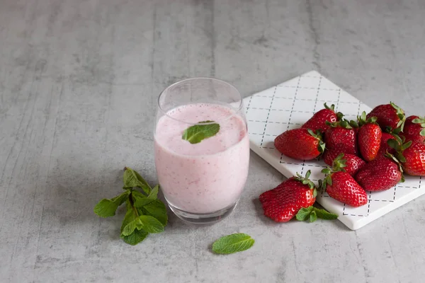 Ein transparentes Glas mit Erdbeer-Milch-Smoothie mit frischen Erdbeeren — Stockfoto