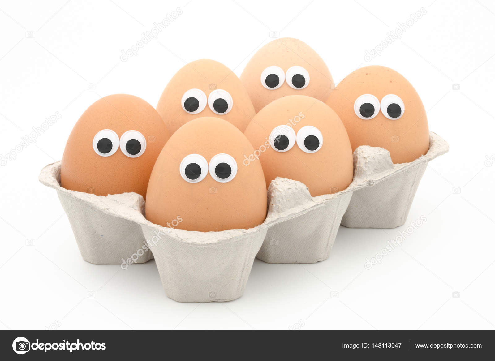 Six eggs in a box with googly eyes on white background — Stock Photo