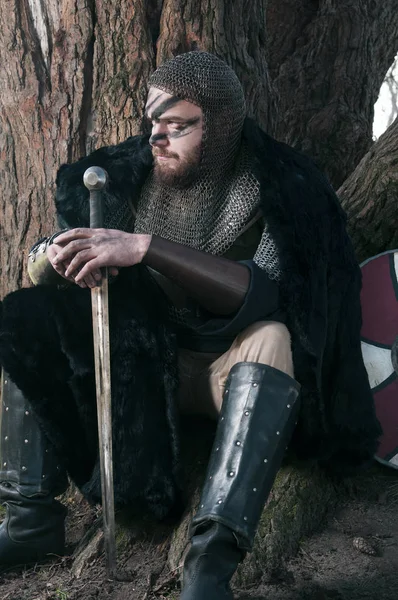 Викинг в мехе, сидящий возле дерева — стоковое фото