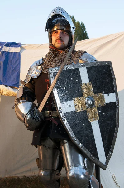 Блестящий рыцарь держит щит и меч — стоковое фото