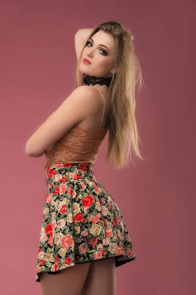 꽃 분홍색 배경에 포즈와 예쁜 옷에서 아름 다운 젊은 여자의 패션 사진. 패션 사진 스톡 사진