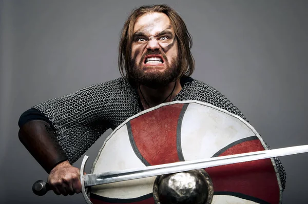 Gritando vikingo con su espada y escudo sobre el fondo gris — Foto de Stock