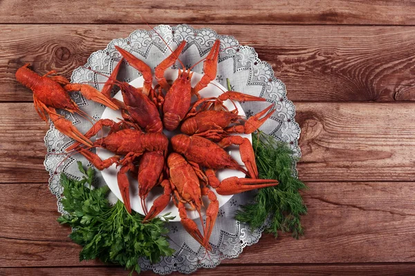 Ahşap zemin üzerine dereotu ile kırmızı haşlanmış kerevit