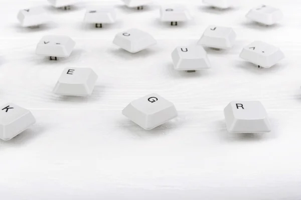 Κλειδιά πληκτρολογίου απομονώθηκαν. Λευκά πλήκτρα πληκτρολογίου σε λευκό ξύλινο φόντο. Στο πάνω μέρος. Κλείσε. — Φωτογραφία Αρχείου