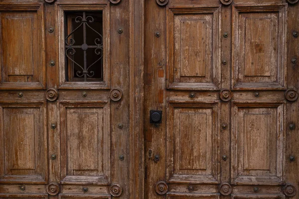 Old wooden textured big doors, old wall with vintage elements, brown beautiful textured wooden old gates.