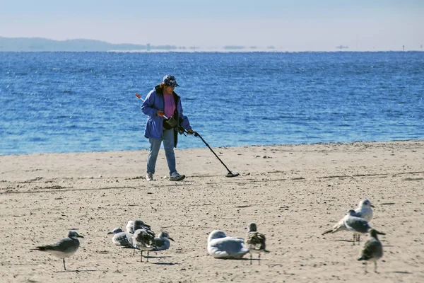 Nova York, EUA - 29 de outubro de 2007: mulher procurando objetos perdidos na areia com detector de metais em Brighton Beach — Fotografia de Stock