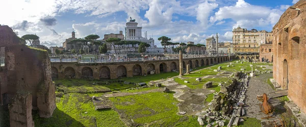 Bekijken via de oude ruïnes van het Forum van Trajanus naar de zuil van Trajanus in Rome, Italië. panorama van de enorme omvang — Stockfoto