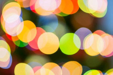 Odak dışında süslenen Noel ağacı tarafından renkli ışıklar yaktı