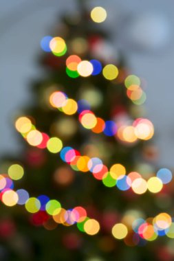 Odak dışında süslenen Noel ağacı tarafından renkli ışıklar yaktı