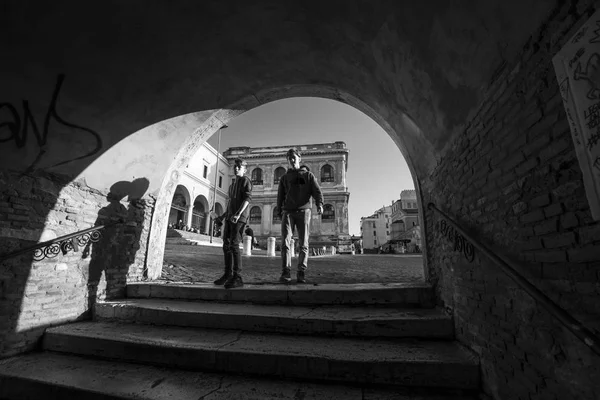 Rome, Italië - 18 November 2016: tieners werpen schaduw in boog van gebouw. zwart-wit fotografie — Stockfoto