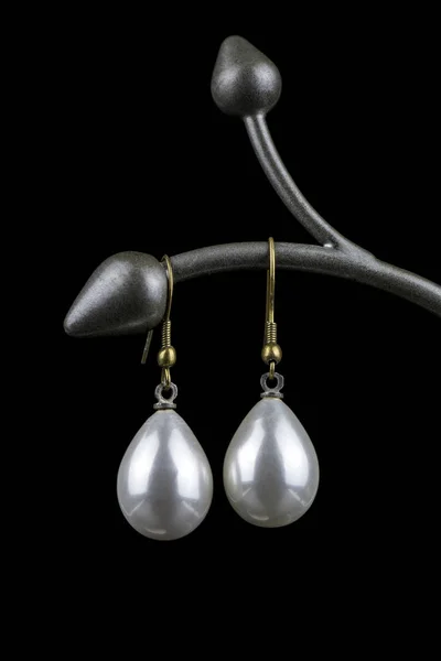 Pendientes de perlas blancas en forma de gota sobre fondo negro —  Fotos de Stock