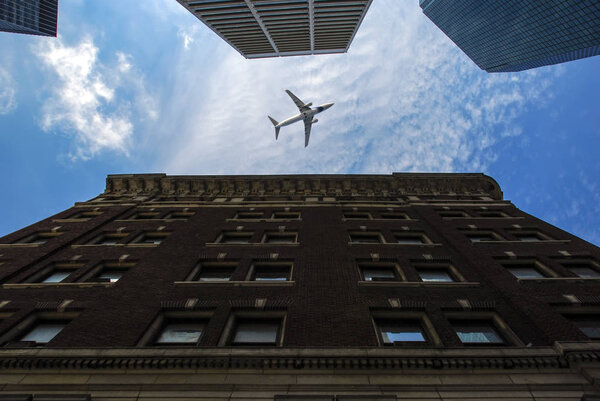 Low angle view of Manhattan skyscrapers with aircraft between them
