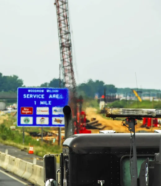 Uitlaatpijp van een vrachtwagen tegen vervagen door rook achtergrond van verkeersbord. zichtbare verontreiniging — Stockfoto