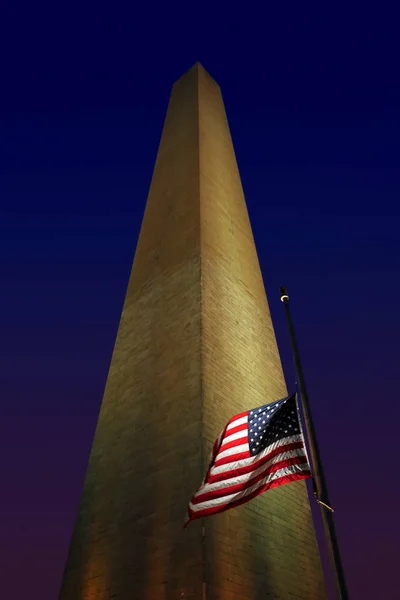 Washington Monument and american flag under blue evening sky, Washington DC, EE.UU. — Foto de Stock