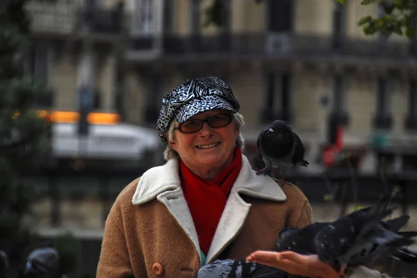 Paris, France - October 01, 2008: French woman with pigeon sitting on her shoulder looking directly to the camera and smiling around Notre Dame de Paris — Stock Photo, Image