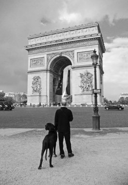 Paris, Fransa - 25 Eylül 2008: Paris Arc de Triumph önünde büyük bir siyah Kraliyet köpek ile. siyah ve beyaz fotoğraf