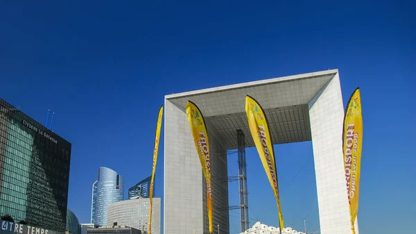 París, Francia - 26 de septiembre de 2008: Grande Arch en La Defense y carteles amarillos contra el cielo azul claro — Foto de Stock