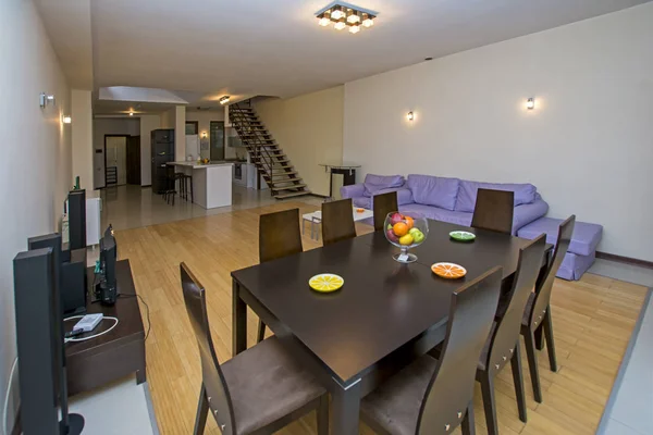 Um moderno apartamento sala de estar com mesa de madeira e cadeiras. Apartamento de luxo com design de interiores moderno e elegante — Fotografia de Stock
