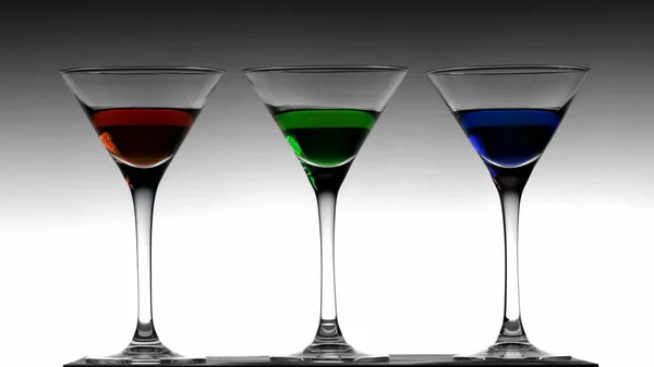 Három elegáns koktél pohár a Színátmenet fekete-fehér alapon piros, a zöld és a kék likőr — Stock Fotó