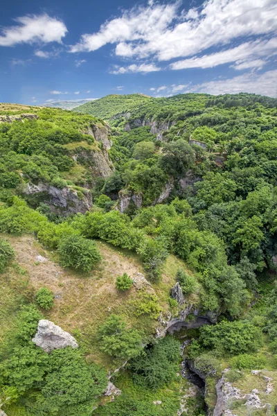 Festői kilátással a Khndzoresk barlang település gyönyörű Canyon (13. századi, használt 1950-ig lakott) a függőhíd, Syunik region, Örményország — Stock Fotó