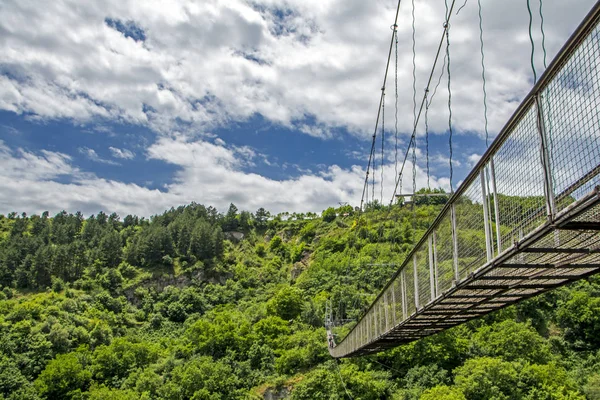 Puente colgante sobre hermoso cañón en el asentamiento de la cueva Khndzoresk (siglo XIII, solía estar habitado hasta la década de 1950), región de Syunik, Armenia — Foto de Stock