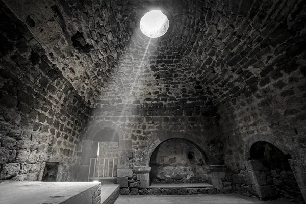 interior of utility room at Tatev monastery, pierced with sunbeam, 9-th century, Armenia. black and white photography