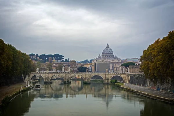 Вид на мост Понте-Сант-Анджело и базилику Святого Петра с отражением в реке Тибр с моста Понте-Умберто I, Рим, Италия. Драматическое осеннее небо — стоковое фото
