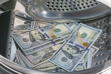 Bize 100 dolar ve elli dolar faturaları yığını Close-Up çamaşır makinesine yerleştirilir. Para aklama kavramı 