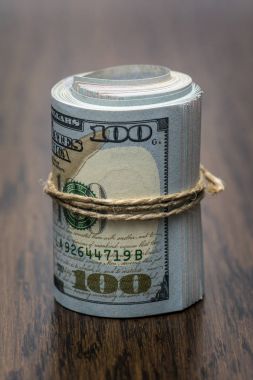 Amerikan Doları (Usd, Amerikan Doları) 100 ve 50 dolar banka notları ile bir rulo dışarıda bir sürü para ahşap arka plan üzerinde bir sembolü olarak makro detay. Para masada