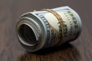 Amerikan Doları (Usd, Amerikan Doları) 100 ve 50 dolar banka notları ile bir rulo dışarıda bir sürü para ahşap arka plan üzerinde bir sembolü olarak makro detay. Para masada