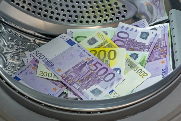 Primer plano de la pila de moneda euro (EUR) con billetes de banco de 500, 200, 100 y 50 euros colocados en la lavadora. Concepto de blanqueo de capitales — Foto de Stock