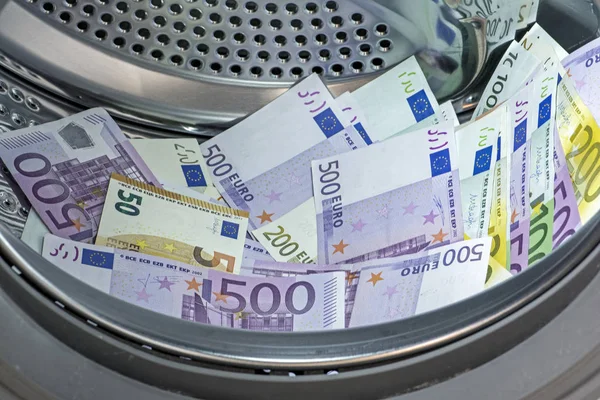 Primer plano de la pila de moneda euro (EUR) con billetes de banco de 500, 200, 100 y 50 euros colocados en la lavadora. Concepto de blanqueo de capitales — Foto de Stock