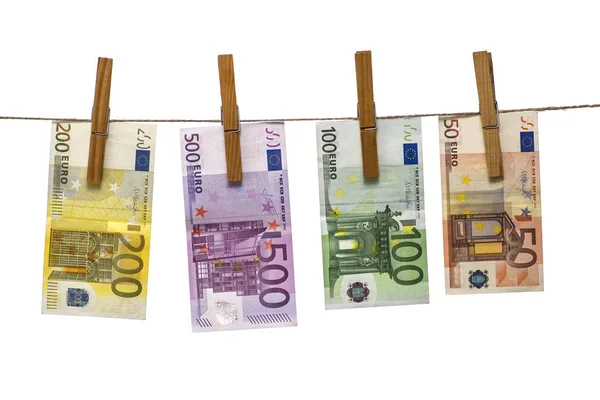 Отмывание денег на веревке с прищепками, изолированными на белом фоне. Валюта евро (EUR) с банкнотами 500, 200, 100 и 50 евро — стоковое фото