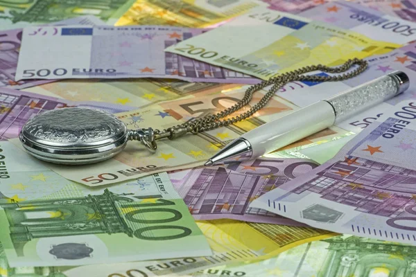 Klassische Taschenuhr und luxuriöser weißer Perlstift auf Eurowährung (Euro) mit 500, 200, 100 und 50-Euro-Scheinen. ein Konzept / eine Idee vom Zeitwert des Geldes (tvm). Zeit ist Geld. Euro-Hintergrund — Stockfoto
