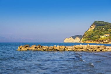 bir derin mavi denizde inanılmaz dik bankaya Villaları ile arka plan, Corfu, Yunanistan ile taş iskele