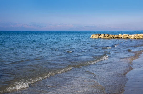 晴れた日、コルフ、ギリシャに深い青色の海の石造り桟橋 — ストック写真