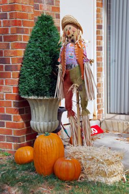 Kabaklar bez korkuluk ve saman ev tuğla duvarın yanında Halloween dekorasyon closeup