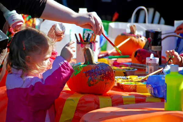 New York, USA - October 28, 2007: Candid scene of parents and children drawing on pumpkin with brush for Halloween — Stock Photo, Image