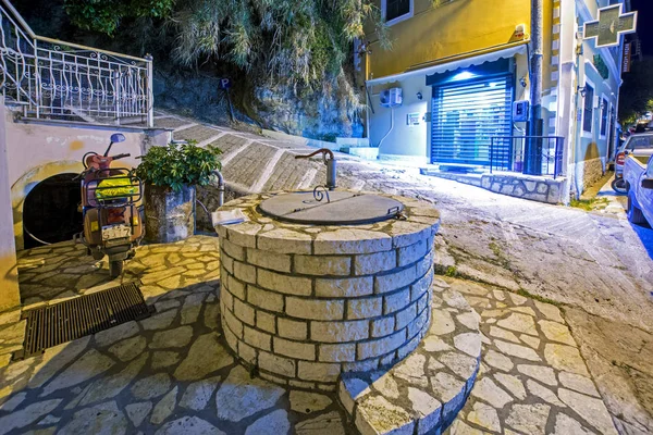 Karousades 2017年8月31日 石圆井在舒适的房子的庭院里 老地中海村庄的夜都市化与狭窄的街道和古色古香的房子 — 图库照片