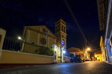 gece cityscape eski Akdeniz Köyü Karousades Ortodoks Kilisesi ve antika evleri, Corfu, Yunanistan ile dar sokak arabalar
