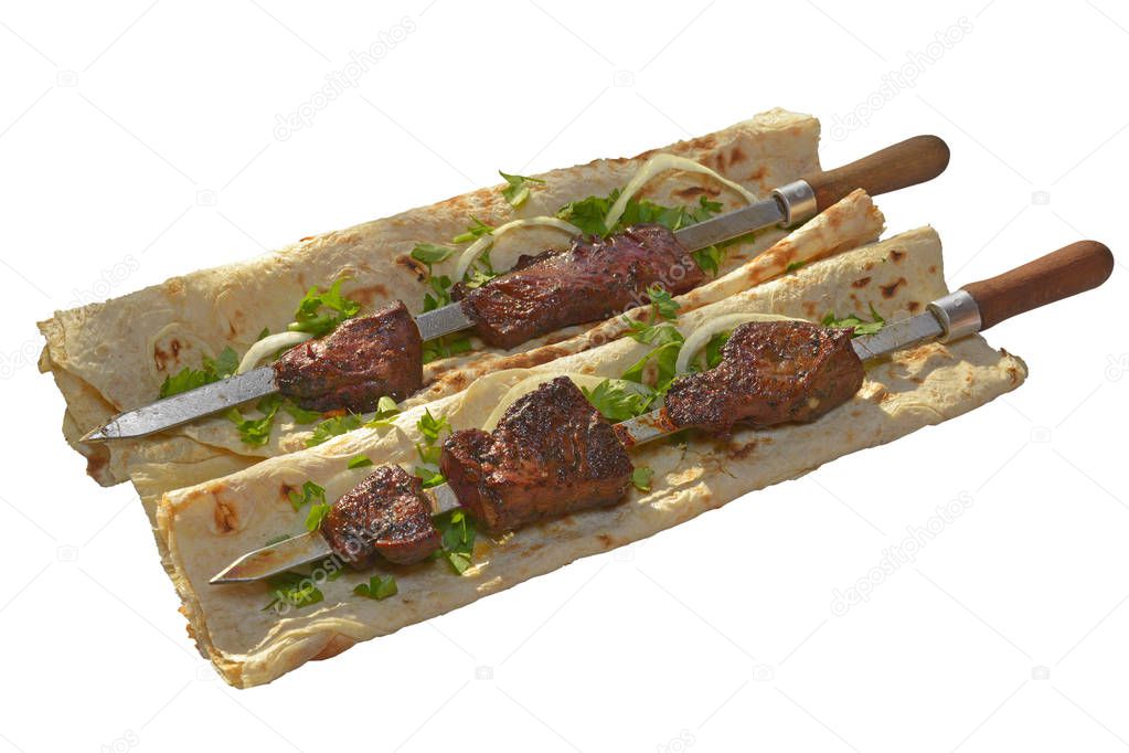 beef lung barbecue on skewer served with sliced onion and parsley on the armenian lavash (pita bread) isolated on white background