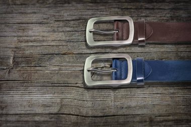 kahverengi ve mavi erkek Deri kemerler ahşap arka plan üzerinde. erkekler moda büyük kemer kahverengi masada. erkek kemerleri arka plan kopya alanı ile Üstten Görünüm