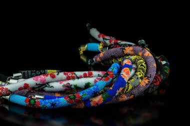 bükülmüş varicoloured parlak boncuklu kolye siyah cam arka planda yansıma yakın çekim ile izole