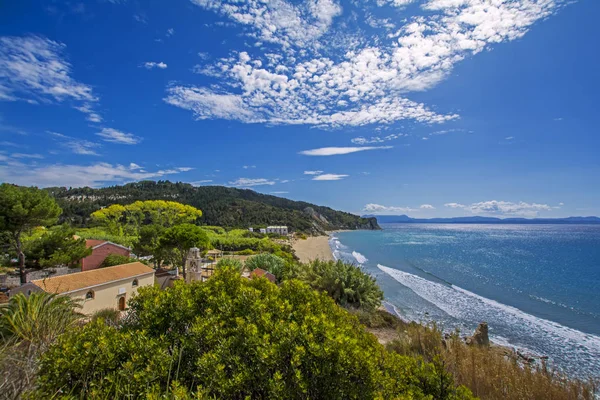 Erikousa Island, Yunanistan eski Ortodoks Kilisesi, masmavi deniz, güneş ve mavi gökyüzü tarafından yaktı yeşil ağaçlar ile güzel görünümü