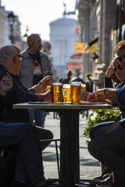Roma, İtalya - 20 Kasım 2016: arkadaşlar açık Cafe Via Nazionale sokakta bira keyfini çıkarın. Altın bira arka tarafından ışık yaktı