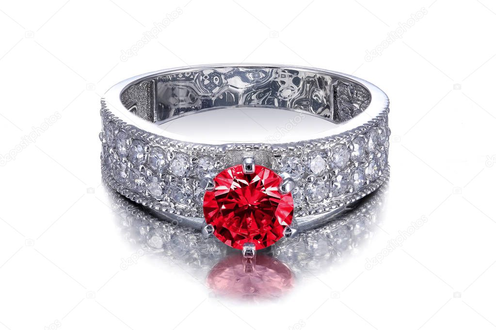 beautiful platinum or white gold, silver diamonds decorative ring with red ruby isolated on a white background with reflection
