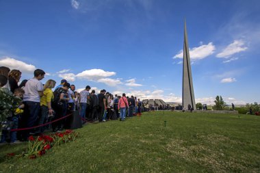 Yerevan, Ermenistan - 24 Nisan 2018: Yas tutanlar Ermeniler çiçeklerle, 1915 Ermeni Soykırımı yıldönümünde Ermeni Soykırımı anma törenine Tsitsernakaberd içinde yürümek. Yeşil çimenlerin üzerinde kırmızı lale
