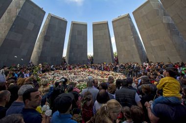Yerevan, Armenia - April 24, 2018: Armenians laying flowers at the eternal flame in the center of the twelve slabs  of Armenian Genocide memorial on anniversary of Armenian Genocide of 1915 clipart